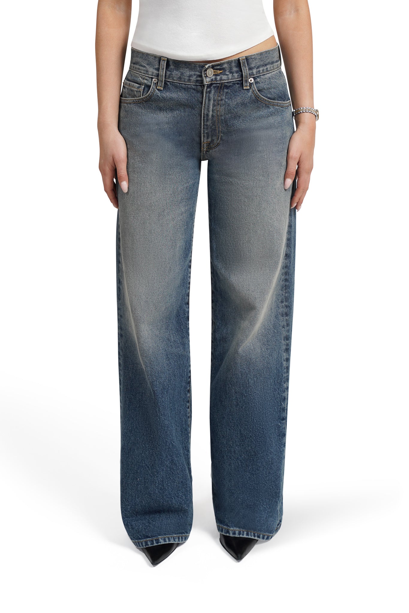 Blue bootcut jeans worn by a person on a white background