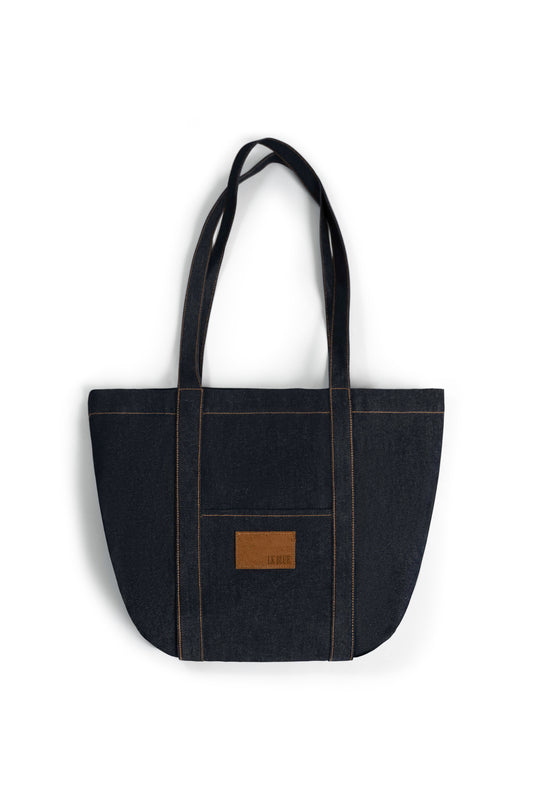 Black denim tote bag with a brown leather patch on a white background