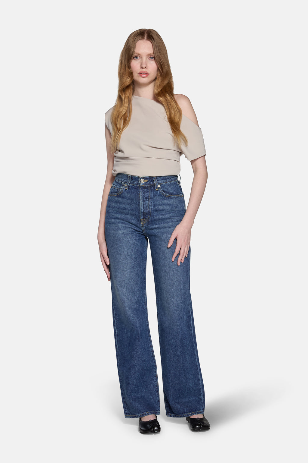 a women wearing biegie top and high rise straight leg jeans in navy 