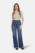 a women wearing biegie top and high rise straight leg jeans in navy 