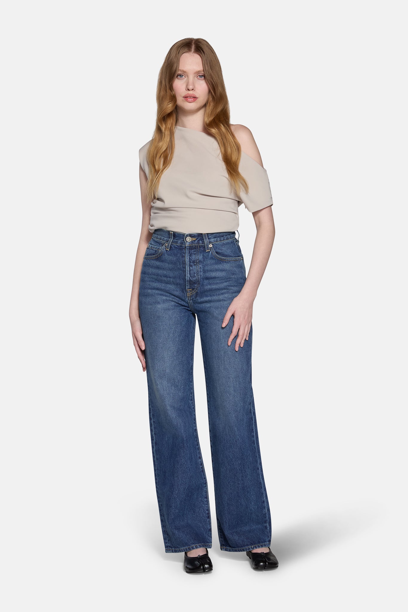 a women wearing biegie top and high rise straight leg jeans in navy 