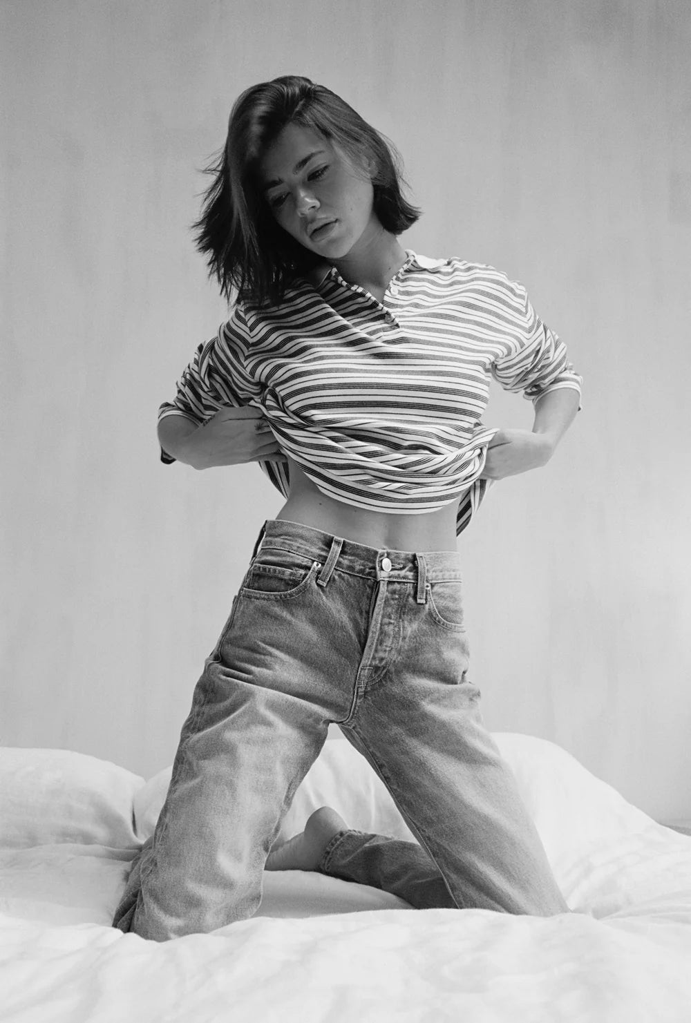Person wearing a striped shirt and jeans on a plain background