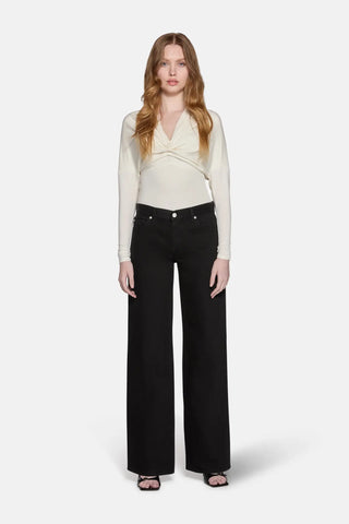 a blonde hair model wearing biegie top with low rise baggy jeans in black 