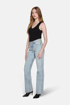 girl wearing black top and light wash bootcut jeans
