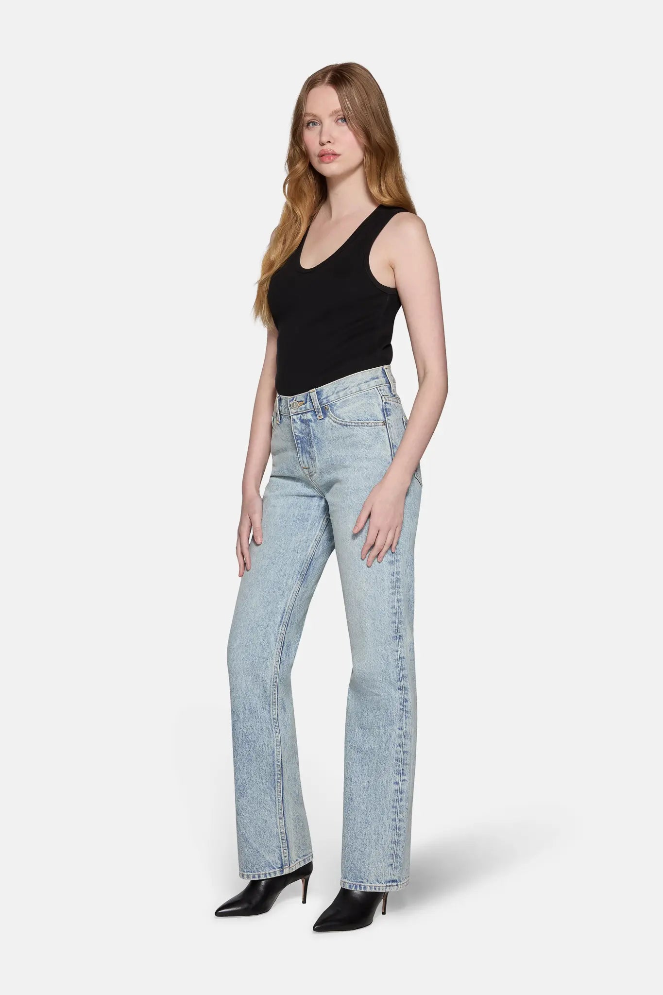 girl wearing black top and light wash bootcut jeans