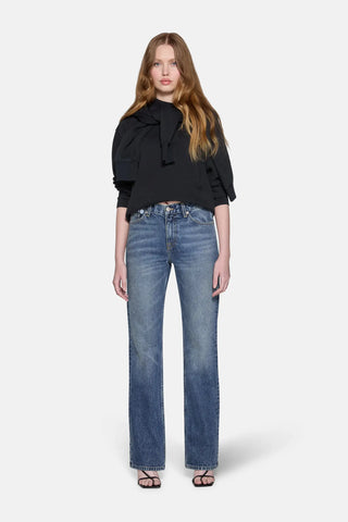 girl wearing black top and blue boot cut jeans 