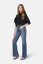 women in blonde hair styled in black top and boot cut jeans for women 