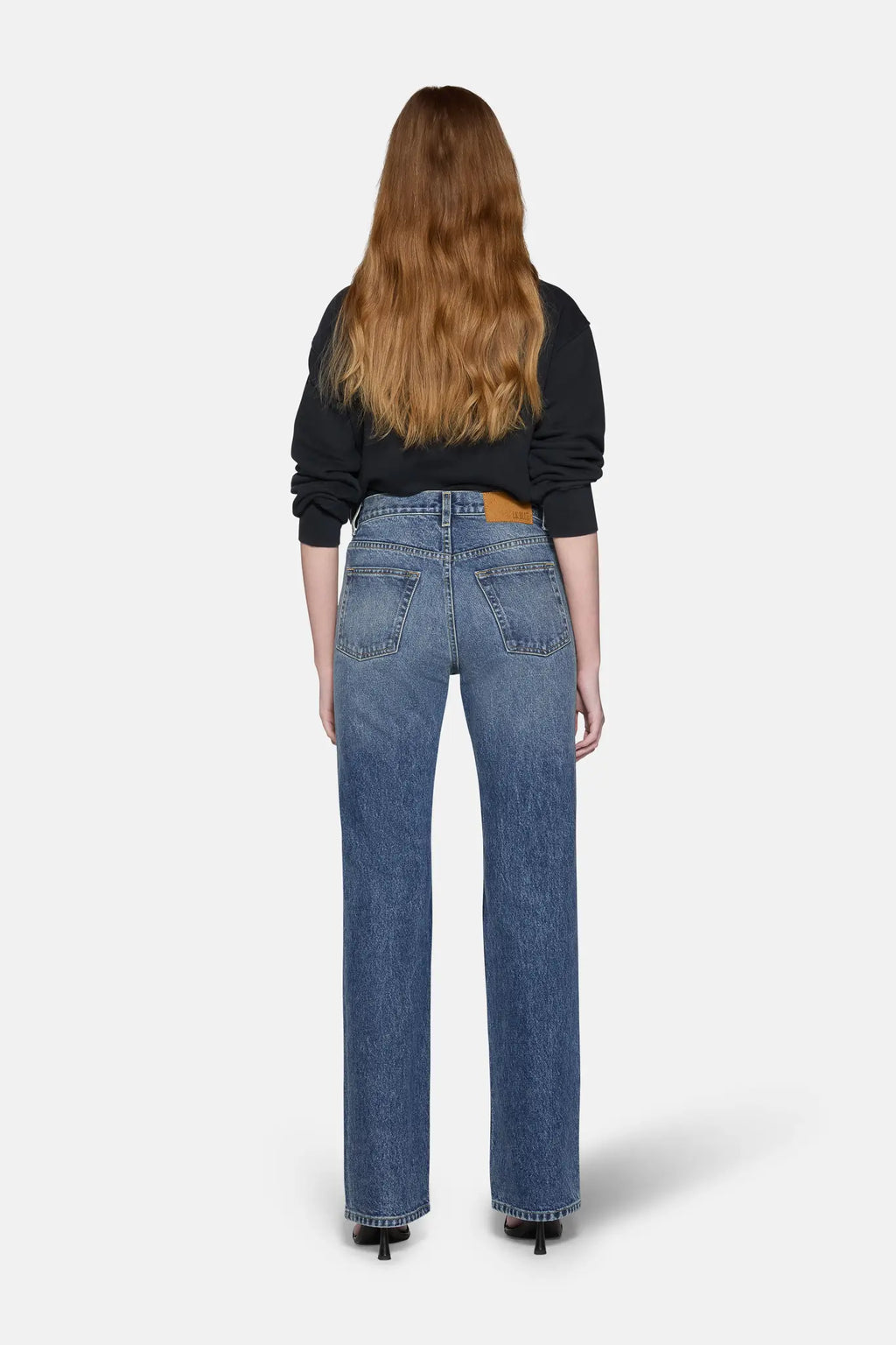 women styled in black top and boot cut jeans for women in blue 