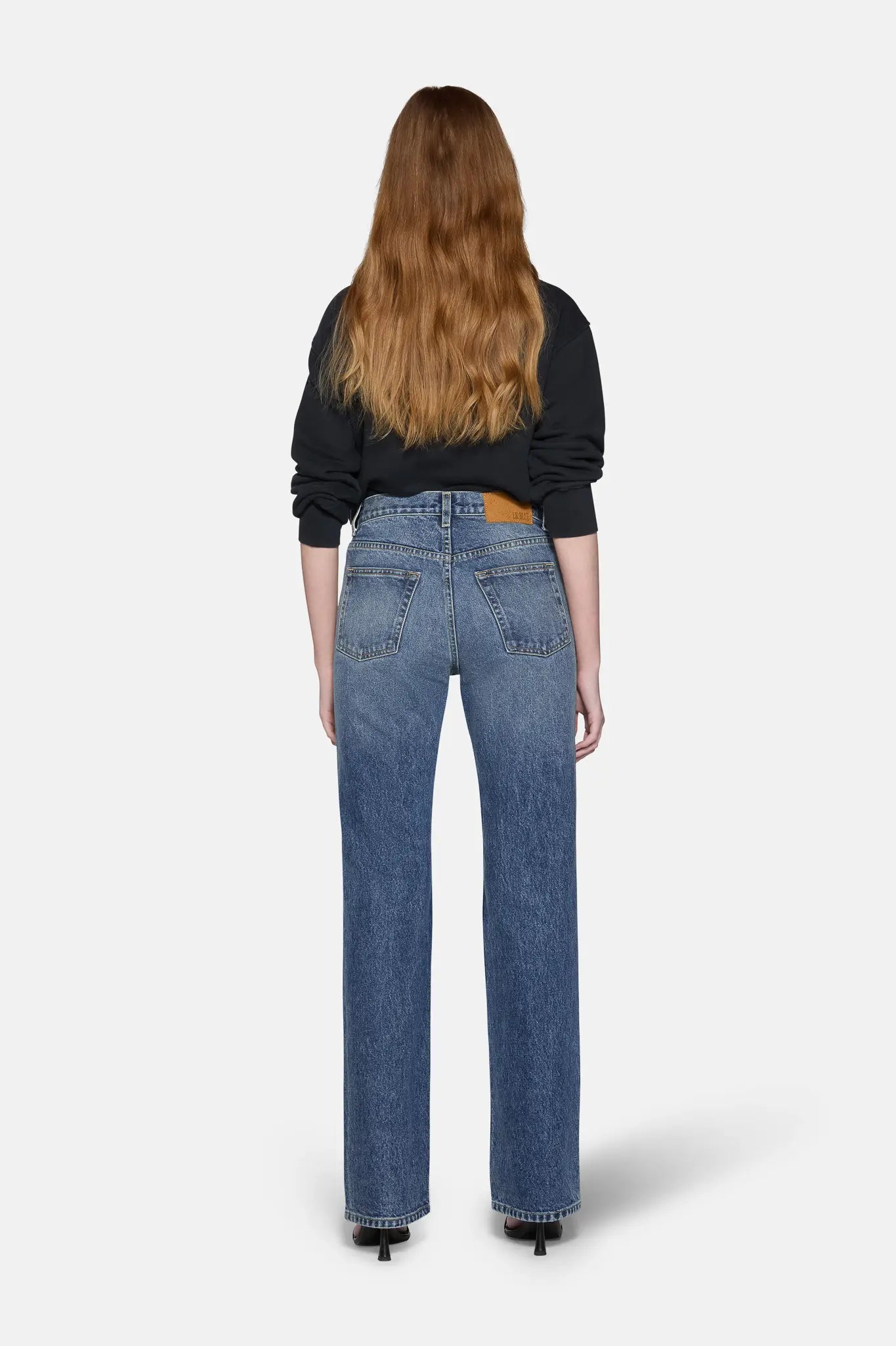women styled in black top and boot cut jeans for women in blue 
