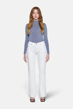 women standing straight wearing grey bluish top with white low rise bootcut jeans 