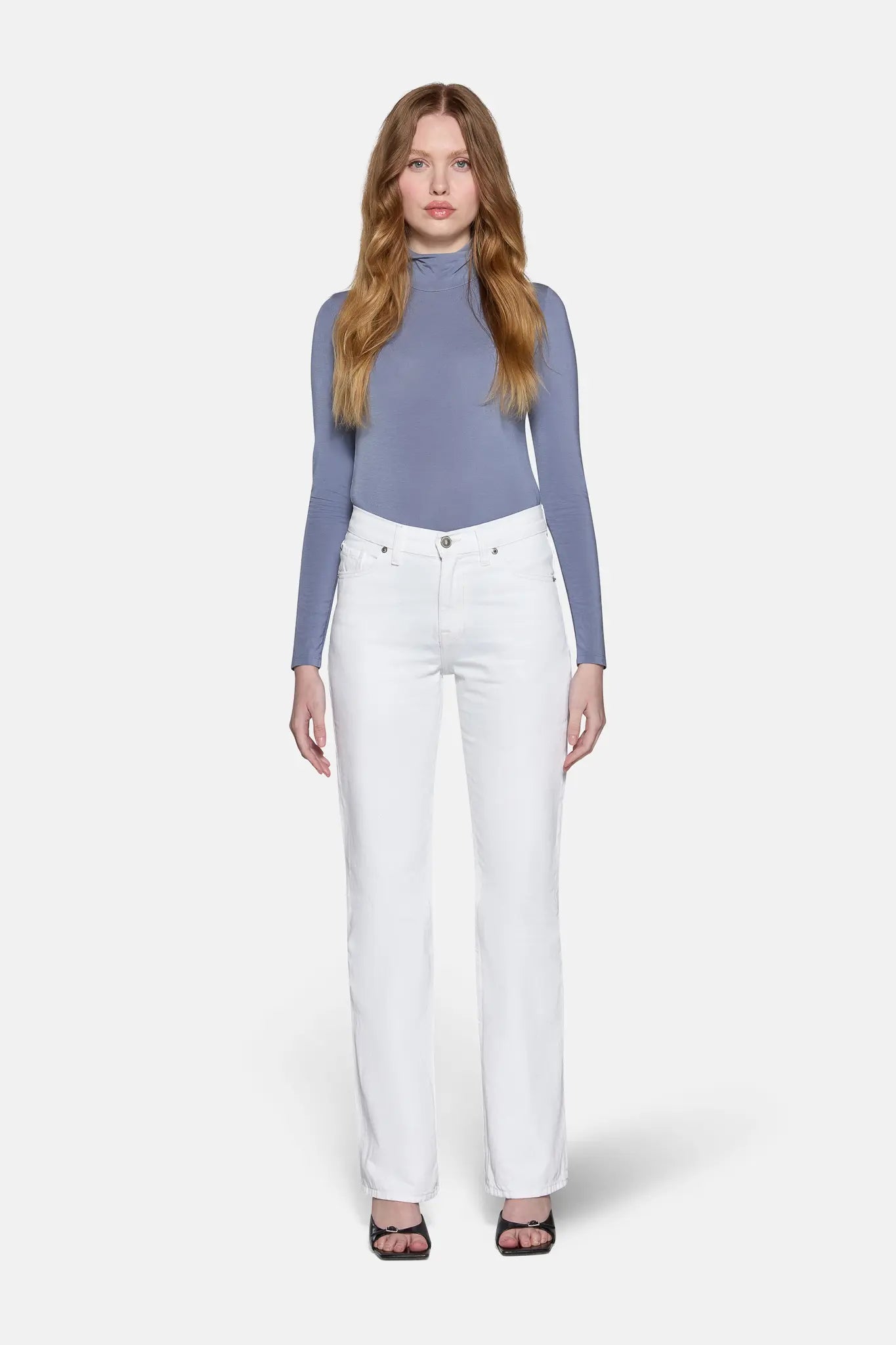 women standing straight wearing grey bluish top with white low rise bootcut jeans 