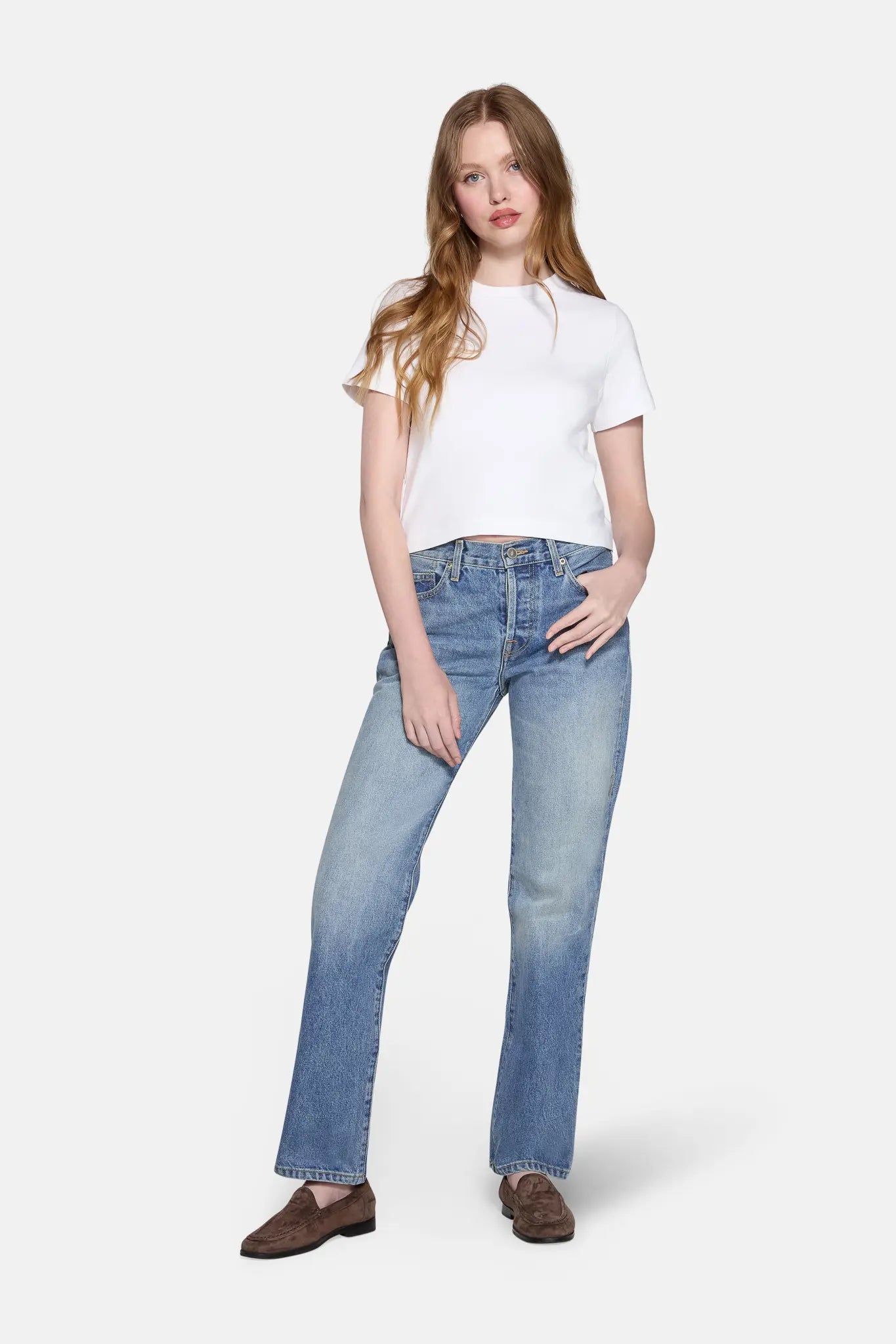 women pictured in light wash straight leg jeans and white tank top 