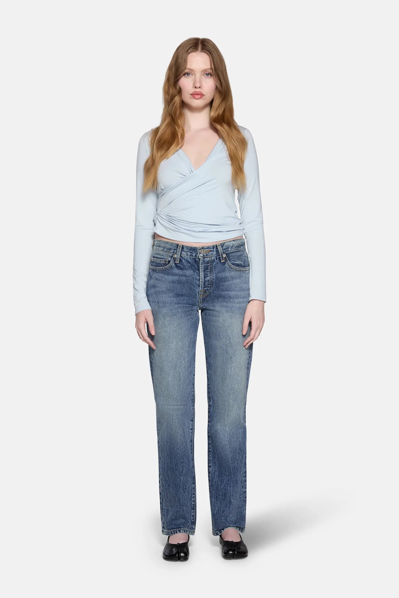 a women wearing blue top with blue low rise straight leg jeans 