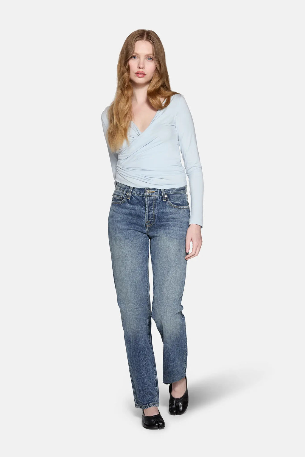 a model styled in blue top and blue low rise straight leg jeans 