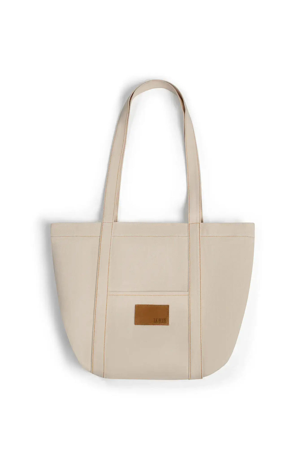 Beige denim tote bag with a brown leather patch on a white background