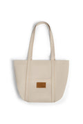 Beige denim tote bag with a brown leather patch on a white background