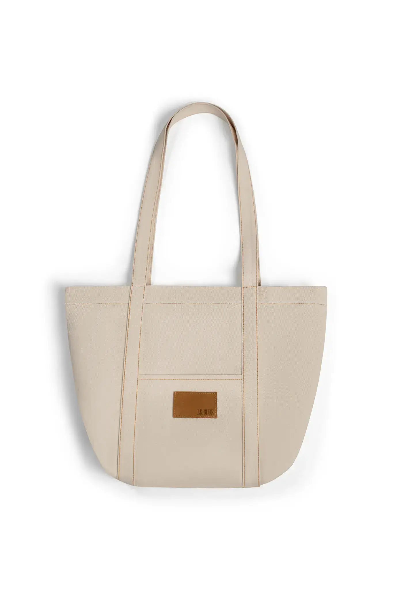 Beige denim tote bag with a brown leather patch on a white background