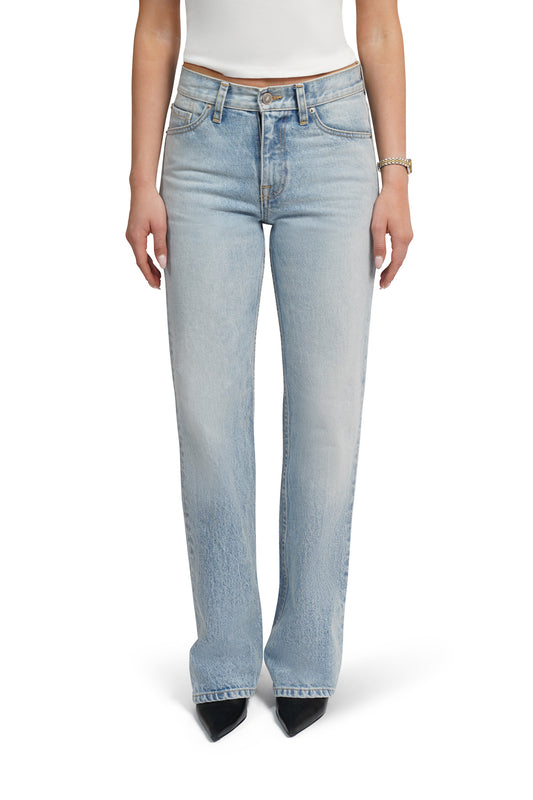 Light blue women boootcut jeans worn by a person on a white background