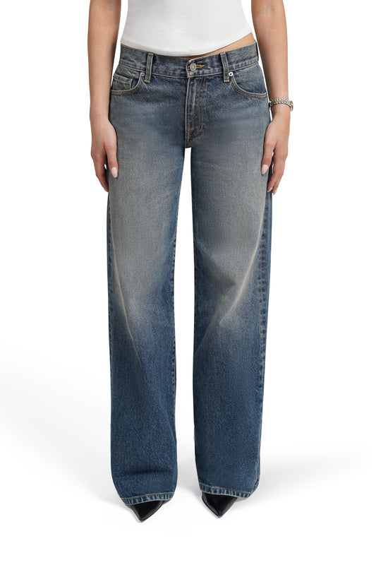Blue  bootcut jeans worn by a person on a white background