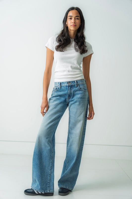Person wearing a white t-shirt and blue jeans against a white background