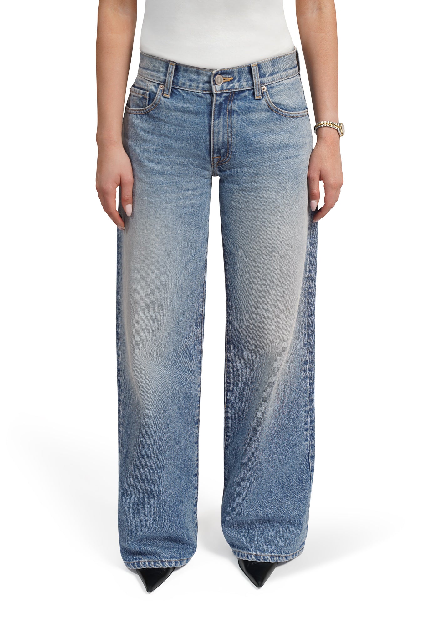 Blue bootcut jeans worn by a person on a white background
