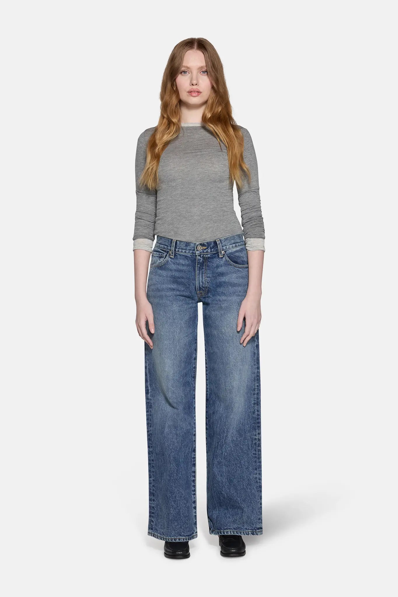 women standing earing gray top with blue low rise baggy jeans for women 