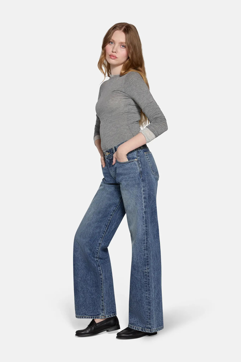 low rise baggy jeans in blue worn  by a women  with grey top 