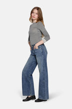 low rise baggy jeans in blue worn  by a women  with grey top 
