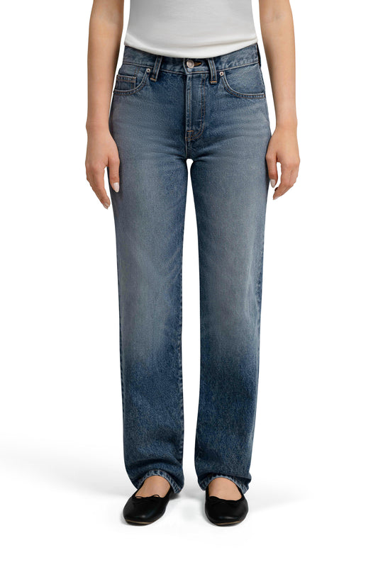 Person wearing blue straight leg denim jeans on a white background