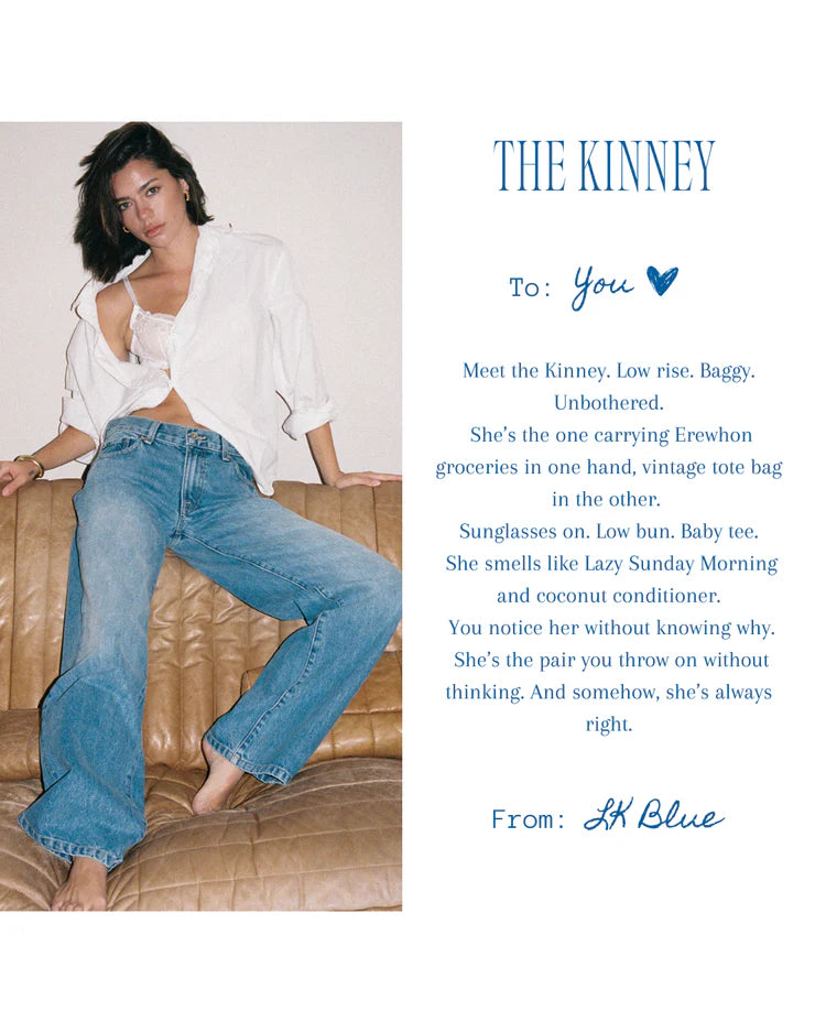 Woman wearing a white shirt and blue jeans sitting on a couch with promotional text about 'The Kinney' jeans.